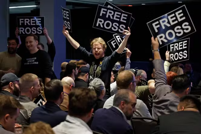Des manifestants tenant des pancartes avec l'inscription "FREE ROSS", ce qui indique un soutien à Ross Ulbricht.